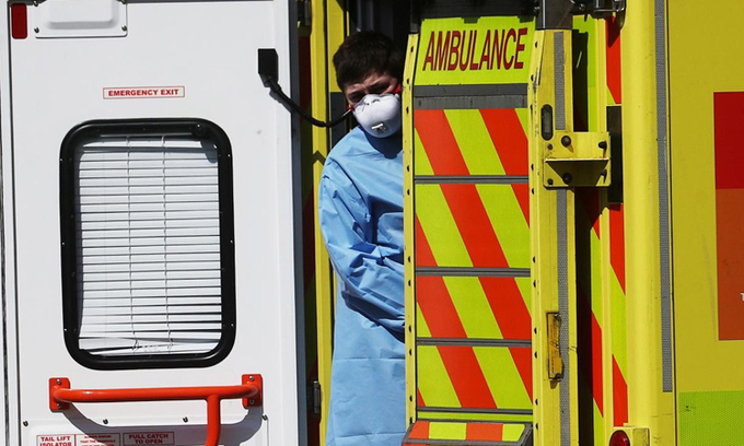 Môt nhân viên y tế đứng sau xe cứu thương bên ngoài bệnh viện Lewisham ở London, Anh hôm 20/4. Ảnh: Reuters.