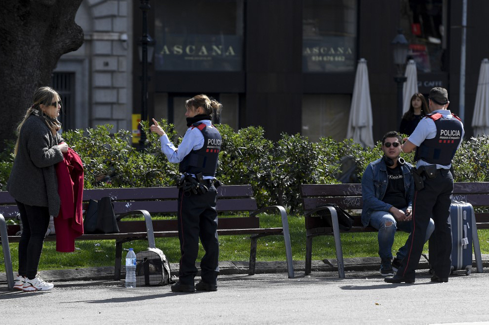 Cảnh sát chất vấn người đi đường tại thành phố Barcelona. Ảnh: AFP.