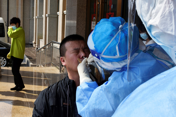 Nhân viên y tế lấy mẫu dịch để xét nghiệm nCoV ở thành phố Tuy Phân Hà hôm 16/4. Ảnh: Reuters