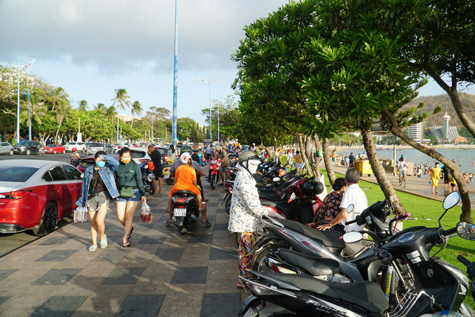 Ôtô, xe máy của người đi tắm biển đậu trên đường Quang Trung. Ảnh: Trường Hà.