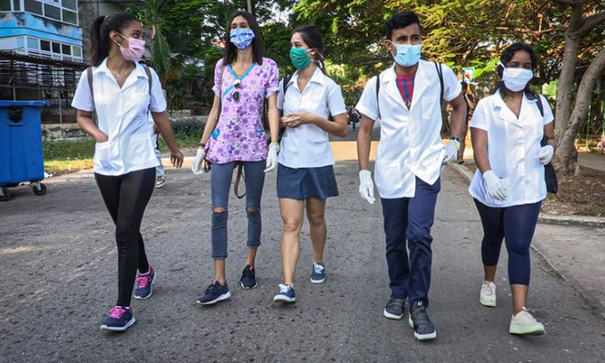 Sinh viên y Cuba tới từng nhà người cao tuổi nhằm phát hiện các trường hợp nhiễm Covid-19. Ảnh: AFP.