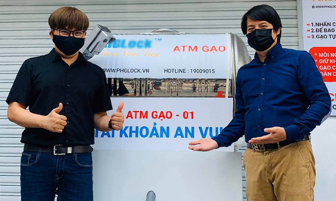 Đại Nghĩa (trái) và anh Hoàng Tuấn Anh - tác giả thiết bị - bên chiếc ATM gạo đầu tiên trong dự án của anh. Ảnh: Nhân vật cung cấp.