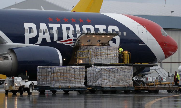 Các thùng khẩu trang được dỡ khỏi máy bay tại Boston hôm 2/4. Ảnh: AP.