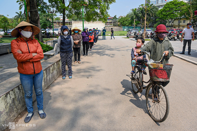 Người dân xếp hàng tại nhà văn hoá phường Nghĩa Tân (quận Cầu Giấy, Hà Nội) để nhận gạo miễn phí từ ATM gạo. Ảnh: Giang Huy.