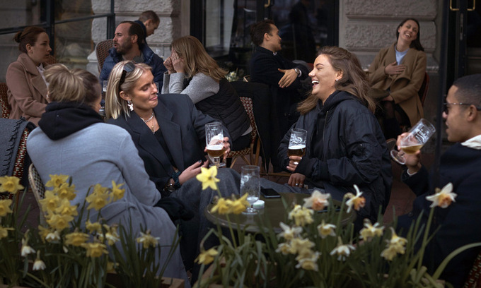 Khách hàng nói chuyện ngoài một quán bar ở thủ đô Stockholm ngày 8/4. Ảnh: AP.