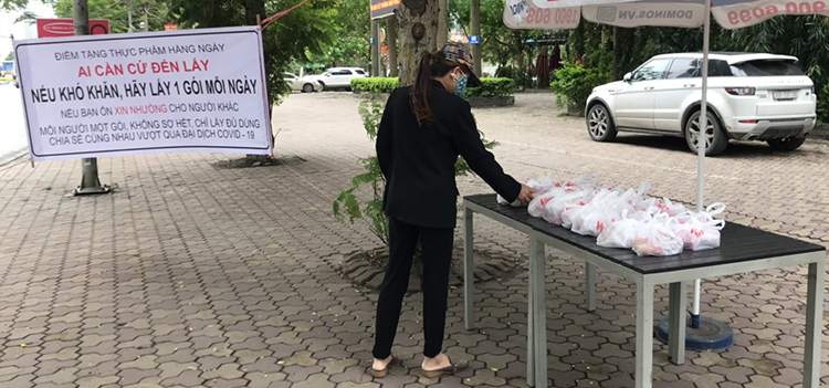 Cô Nguyễn Thị Hoa đến nhận phần thực phẩm tại điểm phát miễn phí trên đường Lê Văn Lương sáng ngày 9/4. Ảnh: Hải Hiền.