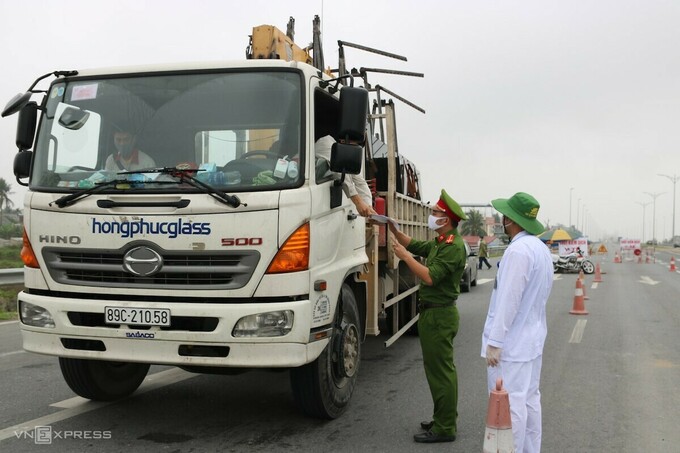 Một tài xế trình giấy xác nhận ra vào thành phố cho cảnh sát, ngày 10/4. Ảnh: Giang Chinh