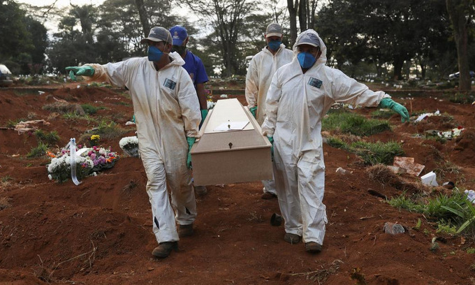 Công nhân mặc đồ bảo hộ chôn cất nạn nhân Covid-19 tại nghĩa trang ở ngoại ô Sao Paulo, Brazil hôm 20/5. Ảnh: Reuters.