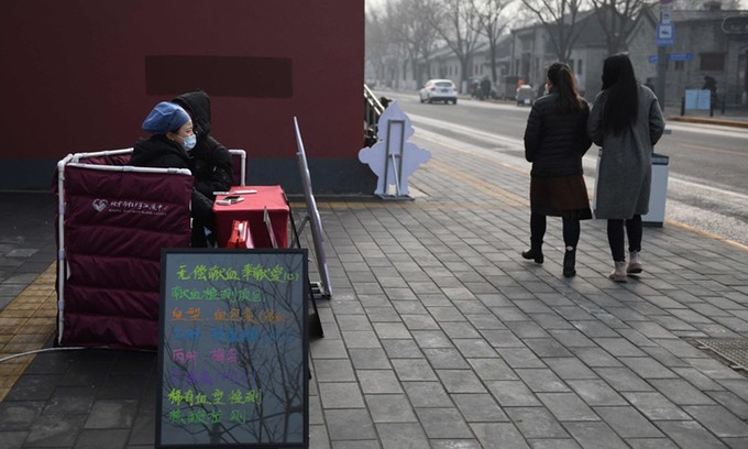 Nhân viên Hội Chữ thập đỏ (trái) chờ người tới đăng ký hiến máu tại Bắc Kinh, hồi tháng 2. Ảnh: AFP.