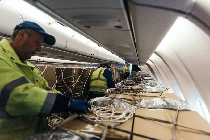 Hàng hóa được chất đầy trên cabin chở khách trong một chiếc máy bay. Ảnh: NYT
