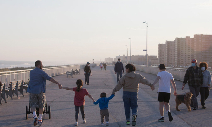 Một gia đình Mỹ đi dạo trên con đường gần bãi biển Rockaway ở Queens, New York, chiều 2/5. Ảnh: NYTimes.