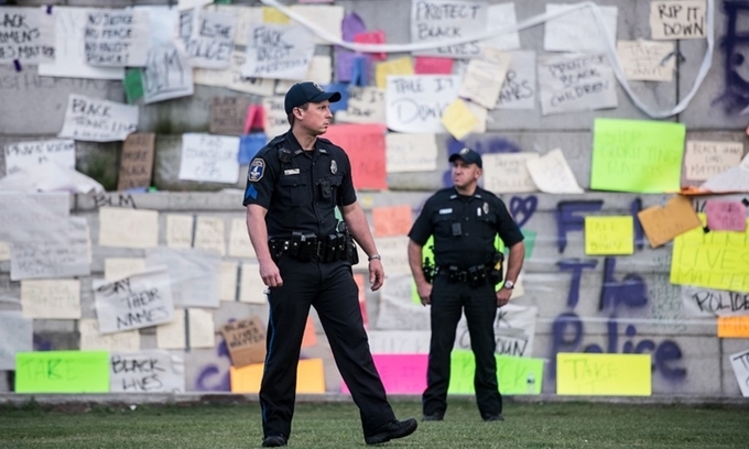 Cảnh sát Charleston bảo vệ khu vực phía dưới bức tượng cựu phó tổng thống Mỹ John Caldwell Calhoun hôm 17/6. Ảnh: AFP.