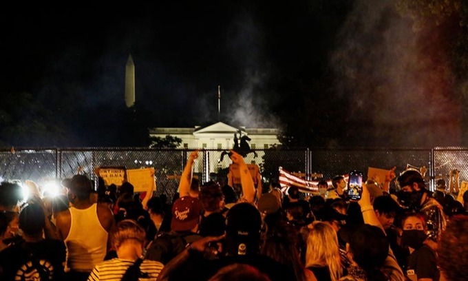 Người biểu tình tập trung phía sau hàng rào lưới thép mới dựng lên trước Nhà Trắng hôm 4/6. Ảnh: Reuters.