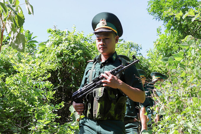 Bộ đội biên phòng bồng súng, xẻ rừng đi truy tìm phạm nhân sự. Ảnh: Nguyễn Đông.