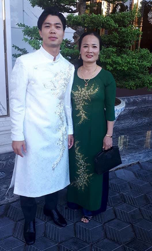 Công Phượng chụp cùng vợ HLV Trương Quang Vinh. Tiền đạo xứ Nghệ mặc chiếc áo dài trắng có in hình rồng phượng.
