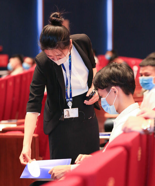 Một giám thị kiểm tra tài liệu của ứng viên trước giờ làm bài.