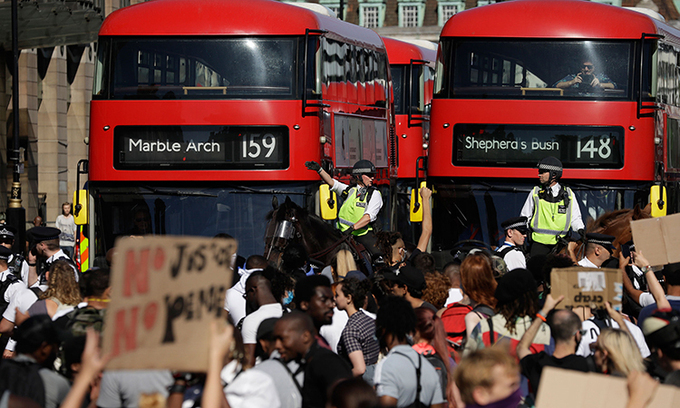 Cảnh sát giám sát biểu tình bên ngoài tòa nhà quốc hội Anh, hôm 31/5. Ảnh: AP.
