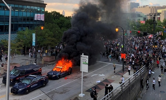 Xe cảnh sát bị đốt trong cuộc biều tỉnh ở Atlanta, Georgia, ngày 29/5. Ảnh: Reuters.