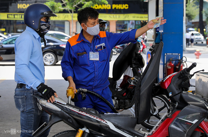 Nhân viên đổ xăng cho khách tại cây xăng ở TP HCM. Ảnh: Như Quỳnh.
