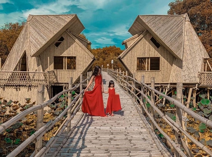 Hai mẹ con diện đồ đôi tạo dáng trên cầu tre. Ảnh Nguyễn Ngọc Hòa