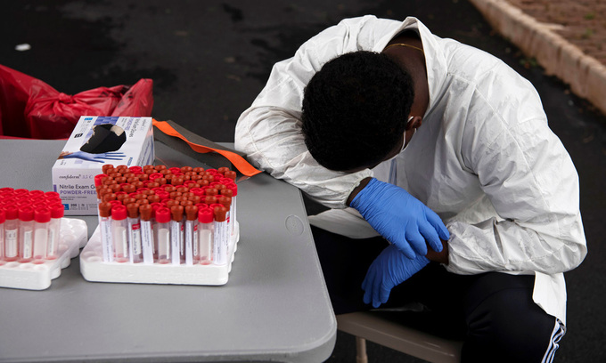 Một nhân viên y tế nghỉ ngơi trong lúc dòng người xếp hàng chờ xét nghiệm nCoV tại thành phố Houston, bang Texas, Mỹ, hôm 7/7. Ảnh: Reuters.