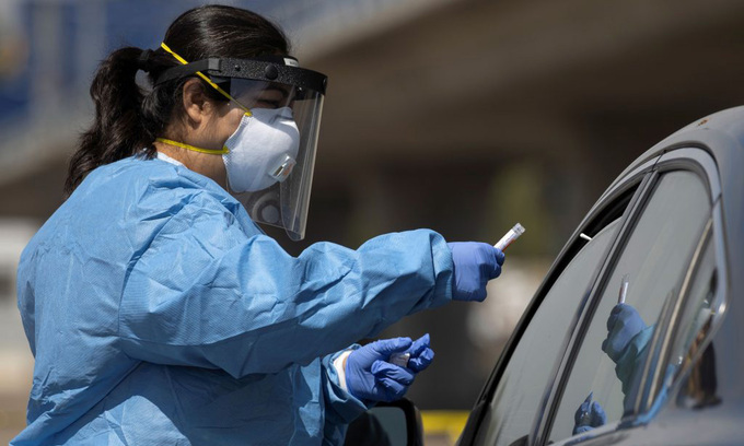 Nhân viên y tế lấy mẫu xét nghiệm nCoV tại một trạm lưu động ở thành phố San Diego, bang California, hôm 25/6. Ảnh: Reuters.