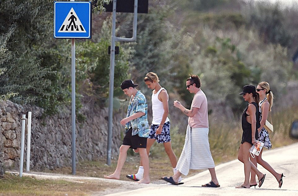 Vic mặc bộ đồ mát mẻ cùng ba con trai lớn và con dâu tương lai rảo bước qua đường trong kỳ nghỉ.