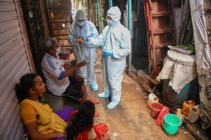 Các nhân viên y tế sàng lọc từng hộ gia đình trong khu ổ chuột Dharavi ở Mumbai hôm 24/6. Ảnh: AFP