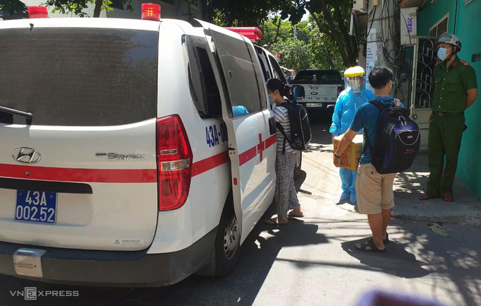 Người nhà bệnh nhân 418 được lực lượng chức năng đưa đi cách ly tập trung, trưa 26/7. Ảnh: Đắc Thành.