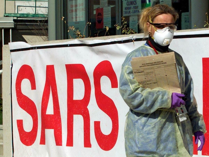 Y tá mặc đồ bảo hộ bên ngoài một phòng khám tại Toronto, Mỹ, trong dịch Sars năm 2003. Ảnh: Reuters
