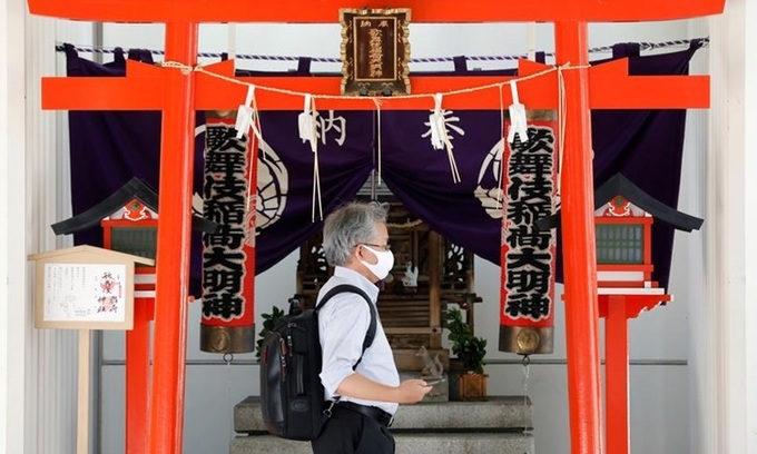 Người đàn ông đeo khẩu trang đi qua cổng đền ở Tokyo, Nhật Bản giữa đại dịch Covid-19 hôm 2/7. Ảnh: Reuters.