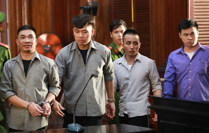 Văn Kính Dương (trái) và các đồng phạm được dẫn vào phòng xử sáng 17/7. Ảnh: Hữu Khoa.