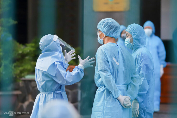 Nhân viên y tế Bệnh viện Đà Nẵng trao đổi công việc bên trong khu vực đã được phong toả, chiều 27/7. Ảnh: Nguyễn Đông.
