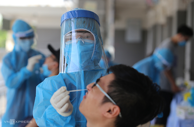Nhân viên y tế Quảng Nam lấy mẫu xét nghiệm Covid-19 người về từ Đà Nẵng. Ảnh: Đắc Thành.