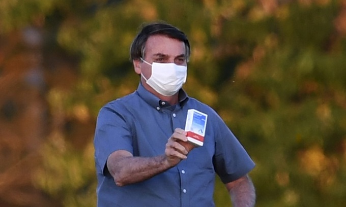 Tổng thống Brazil giơ hộp thuốc chống sốt rét hydroxychloroquine trước những người ủng hộ ở thủ đô Brasilia hôm 23/7. Ảnh: AFP.