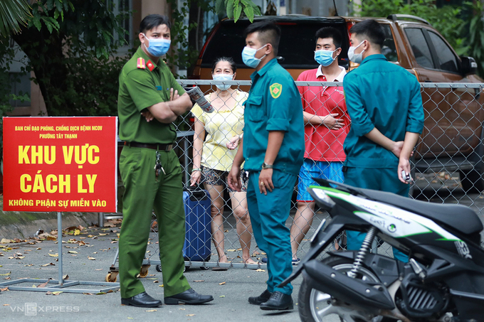 Người phụ nữ manh hành lý xin ra khỏi khu vực phong tỏa bị lực lượng chức năng chặn lại, trưa 1/8. Ảnh. Hữu Khoa.