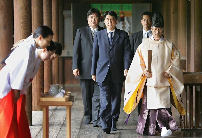 Shinzo Abe đi sau một thầy tu tới  cầu nguyện cho những người đã chết trong chiến tranh ở đền Yasukuni tại Tokyo năm 2013. Ảnh: AFP.