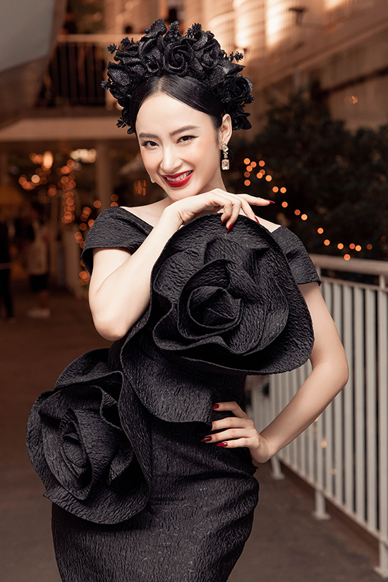 Angela Phương Trinh diện nguyên bộ trang phục đen với phần tạo khối cánh hoa 3D nổi bật. Stylist Hoàng Ku còn chọn thêm bờm cài tóc đồng điệu với bộ cánh.