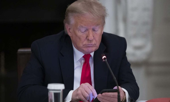 Tổng thống Mỹ Donald Trump nhìn xuống điện thoại trong một cuộc họp ở Nhà Trắng hôm 18/6. Ảnh: AP.