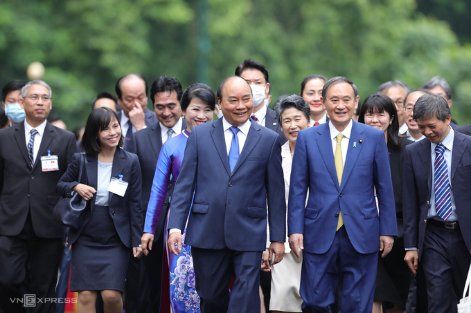 Thủ tướng Nguyễn Xuân Phúc và Thủ tướng Nhật Bản Suga di chuyển từ nơi đón chính thức đến phòng hội đàm trong chuyến thăm Việt nam sáng 19/10. Ảnh: Ngọc Thành.