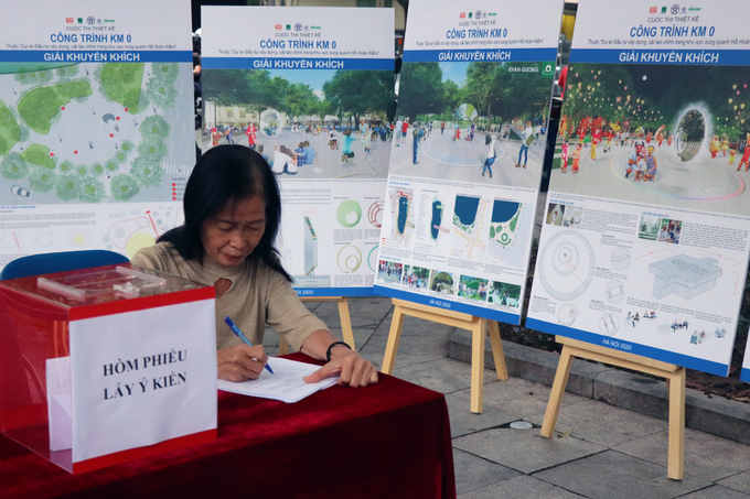 Bà Nguyễn Thị Thanh Hằng, trú tại 22 Hàng Vải, phường Hàng Bộ, quận Hoàn Kiếm đóng góp ý kiến vào các phương án đạt giải cuộc thi thiết kế Km0. Ảnh: Võ Hải.