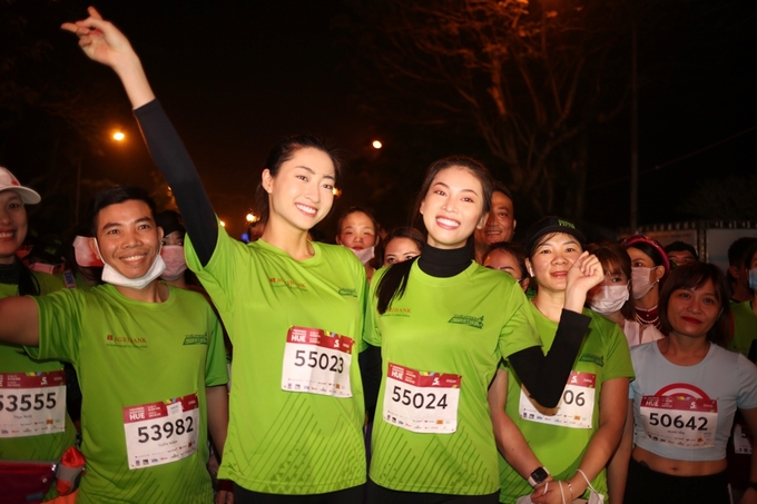 Hoa hậu Lương Thùy Linh và Á hậu Ngọc Thảo diện áo đấu xanh lá, cùng nhóm vận động viên 5 km khởi động. Hai người đẹp hào hứng khi được chạy qua những cung đường đẹp nhất cố đô.