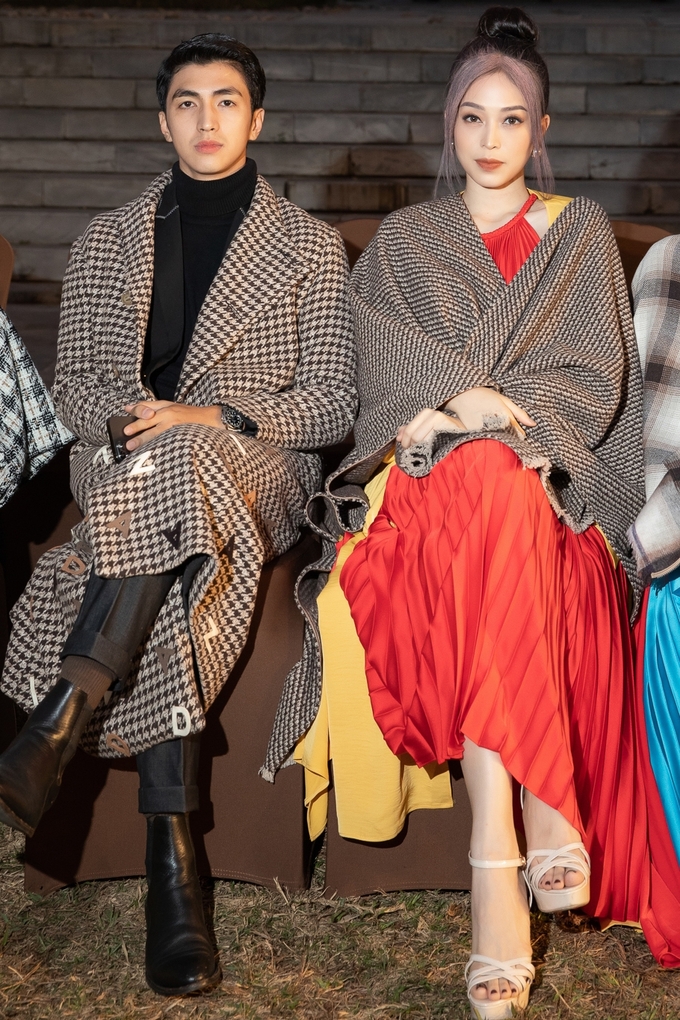 Bình An và bạn gái - hoa hậu Phương Nga - đi xem thời trang với áo khoác và khăn choàng làm từ những chất liệu tweed khác nhau.