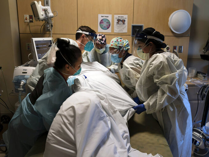 Các nhân viên y tế giúp đặt một bệnh nhân Covid-19 nằm úp tại Trung tâm Y tế Providence Holy Cross ở Los Angeles hôm 19/11. Ảnh: AP.