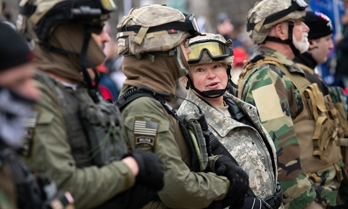 Một nhóm cực hữu ăn mặc phong cách quân đội xếp hàng bảo vệ những người biểu tình ủng hộ Tổng thống Trump tại Freedom Plaza, thủ đô Washington, hôm 5/1. Ảnh: Reuters.