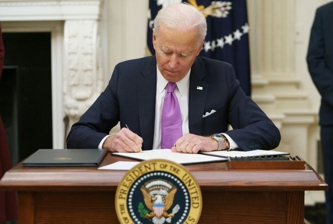 Tổng thống Joe Biden ký sắc lệnh trong ngày đầu nhậm chức hôm 20/1 tại Nhà Trắng. Ảnh: AFP