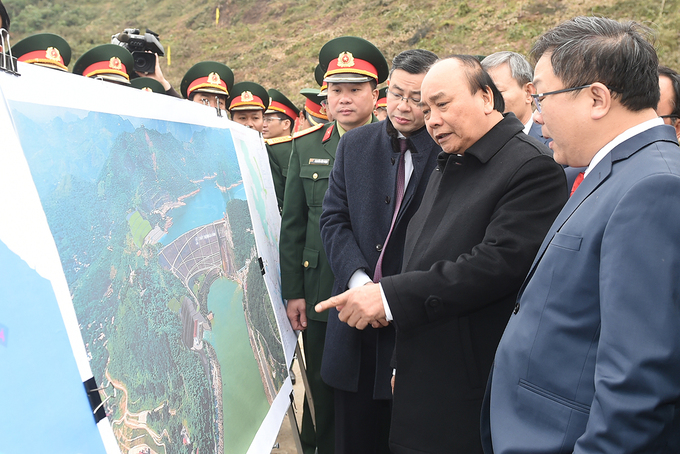 Thủ tướng Nguyễn Xuân Phúc nghe báo cáo về quy mô nhà máy thủy điện Hòa Bình mở rộng, sáng 10/1. Ảnh: Quang Hiếu