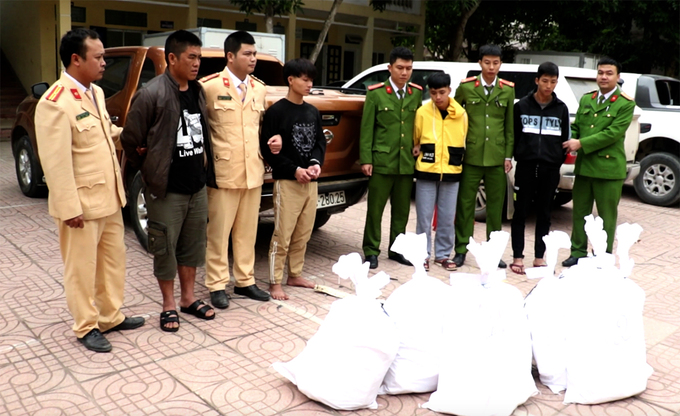 8 bao tải chứa ma túy và nhóm nghi phạm lúc cảnh sát dẫn giải về trụ sở. Ảnh: Phương Linh