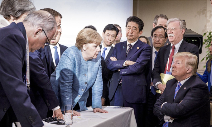 Tổng thống Mỹ ngồi khoanh tay, trước mặt ông là Thủ tướng Đức Angela Merkel và các lãnh đạo G7 khác trong cuộc họp G7 tại Canada tháng 6/2018. Ảnh: AP.