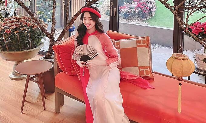 Hoa hậu Đặng Thu Thảo diện áo dài, pose hình khoe khuôn viên trang trí Tết của gia đình. Bà mẹ hai con viết: Xuân về cánh én lượn bay.  Trăm hoa đua nở ngất ngây lòng người.